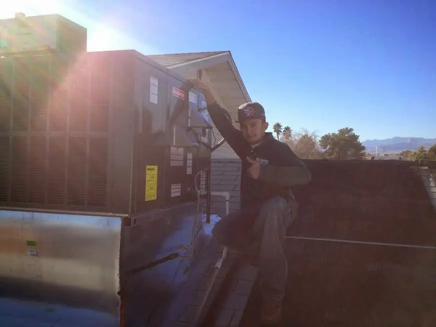 HVAC technician performing AC Tune-Up on a rooftop unit in South Huntingdon